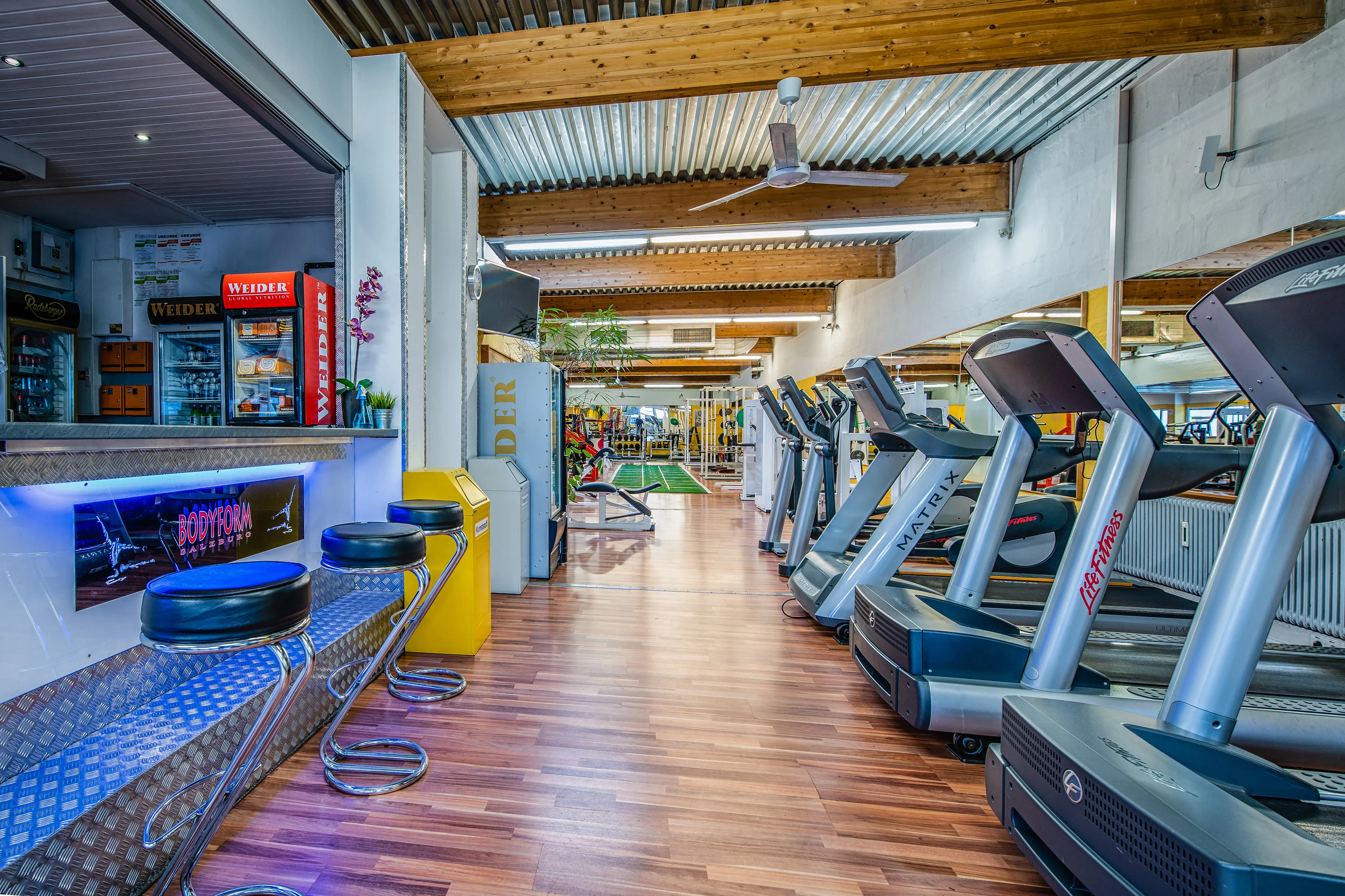 Bar & Cardio Bereich mit Laufbändern, Fahrrädern und Stepper im Bodyform Studio